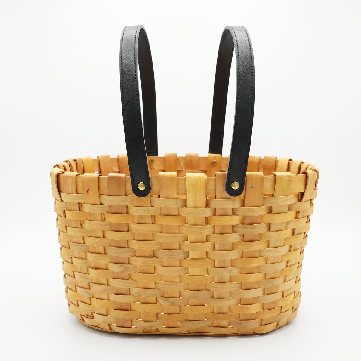 Woven wooden strip basket featuring long black synthetic leather handles secured with metal rivets. Designed in a tote/picnic style, perfect for carrying, organizing, and showcasing gourmet gift sets.
